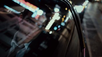 Movie still from “Margin Call” (2011), directed by J.C. Chandor – A blurry picture of a city street at night time; Extreme Close Up shot, Overhead angle