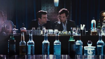 Movie still from “Margin Call” (2011), directed by J.C. Chandor – A couple of men sitting in front of a bar; Medium shot, Over the shoulder angle