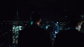 Movie still from “Margin Call” (2011), directed by J.C. Chandor – A man standing in front of a city at night; Medium shot, Low angle