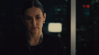 Movie still from “Margin Call” (2011), directed by J.C. Chandor – A woman in a black jacket is looking at the camera; Close Up shot, Over the shoulder angle