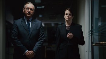 Movie still from “Margin Call” (2011), directed by J.C. Chandor – A man and a woman standing next to each other; Medium shot, Low angle
