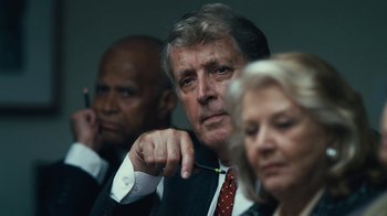 Movie still from “Margin Call” (2011), directed by J.C. Chandor – A man and two women in suits and ties; Close Up shot, Over the shoulder angle