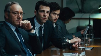 Movie still from “Margin Call” (2011), directed by J.C. Chandor – A group of men sitting at a wooden table; Medium shot, Over the shoulder angle