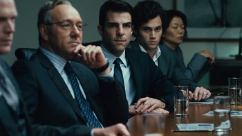 Movie still from “Margin Call” (2011), directed by J.C. Chandor – A group of people sitting at a table; Medium shot, Over the shoulder angle