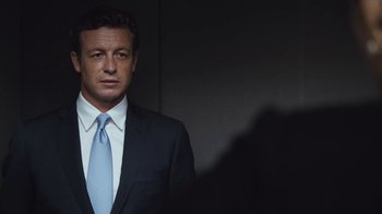 Movie still from “Margin Call” (2011), directed by J.C. Chandor – A person wearing a suit and a tie; Close Up shot, Over the shoulder angle