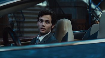 Movie still from “Margin Call” (2011), directed by J.C. Chandor – A man in a suit and tie sitting in the back of a car; Close Up shot, Over the shoulder angle