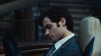 Movie still from “Margin Call” (2011), directed by J.C. Chandor – A man in a suit and tie sitting down; Close Up shot, Overhead angle