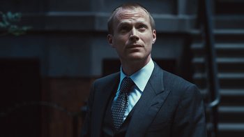 Movie still from “Margin Call” (2011), directed by J.C. Chandor – A person wearing a suit and tie; Close Up shot, Low angle