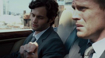 Movie still from “Margin Call” (2011), directed by J.C. Chandor – A man sitting in the back seat of a car next to another man; Close Up shot, Over the shoulder angle