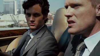 Movie still from “Margin Call” (2011), directed by J.C. Chandor – A man in a suit sitting next to another man in a suit; Close Up shot, Over the shoulder angle