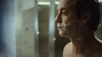Movie still from “Margin Call” (2011), directed by J.C. Chandor – A person in a bathroom; Close Up shot, Over the shoulder angle