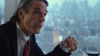 Movie still from “Margin Call” (2011), directed by J.C. Chandor – An older man wearing a suit and tie looking out of a window; Close Up shot, Over the shoulder angle