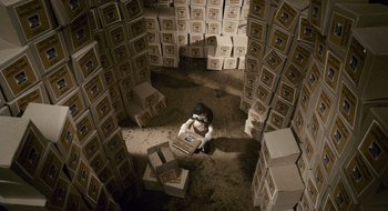 Movie still from “Mary and Max” (2009), directed by Adam Elliot – A woman sitting on a floor surrounded by boxes; Extreme Wide shot, Overhead angle