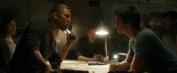 Movie still from “Maze Runner: The Death Cure” (2018), directed by Wes Ball – A group of people sitting around a table; Medium shot, Over the shoulder angle