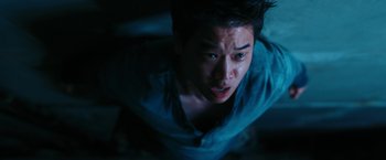 Movie still from “Maze Runner: The Death Cure” (2018), directed by Wes Ball – A man in a blue shirt is looking up at the camera; Close Up shot, Overhead angle
