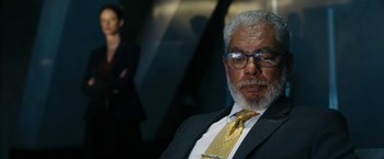 Movie still from “Maze Runner: The Death Cure” (2018), directed by Wes Ball – An older man wearing a suit and tie; Close Up shot, Over the shoulder angle