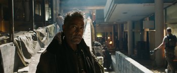 Movie still from “Maze Runner: The Death Cure” (2018), directed by Wes Ball – A man standing in front of a building with people; Close Up shot, Over the shoulder angle