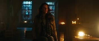 Movie still from “Maze Runner: The Death Cure” (2018), directed by Wes Ball – A woman sitting in front of a window in a dark room; Medium shot, Low angle