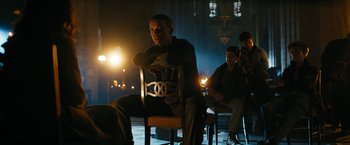 Movie still from “Maze Runner: The Death Cure” (2018), directed by Wes Ball – A man sitting in a chair in a dark room; Wide shot, Low angle