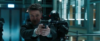 Movie still from “Maze Runner: The Death Cure” (2018), directed by Wes Ball – A man holding a gun in front of another man; Medium shot, Over the shoulder angle