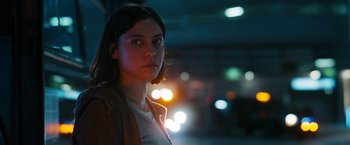 Movie still from “Maze Runner: The Death Cure” (2018), directed by Wes Ball – A young woman standing in the dark near some lights; Close Up shot, Over the shoulder angle