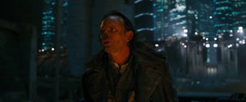 Movie still from “Maze Runner: The Death Cure” (2018), directed by Wes Ball – A man in a trench coat standing in front of a building at night; Close Up shot, Over the shoulder angle