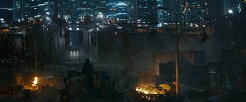 Movie still from “Maze Runner: The Death Cure” (2018), directed by Wes Ball – A man standing next to a fire pit in a city; Extreme Wide shot, High angle