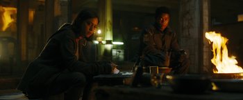 Movie still from “Maze Runner: The Death Cure” (2018), directed by Wes Ball – A man and a woman sitting in a dimly - lit room; Medium shot, Low angle