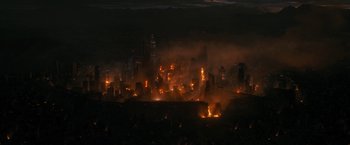 Movie still from “Maze Runner: The Death Cure” (2018), directed by Wes Ball – A large city is lit up by fire at night; Extreme Wide shot, High angle