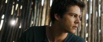 Movie still from “Maze Runner: The Death Cure” (2018), directed by Wes Ball – A young man's face in front of a bunch of trees; Close Up shot, Over the shoulder angle