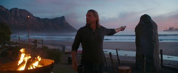 Movie still from “Maze Runner: The Death Cure” (2018), directed by Wes Ball – A man standing on a beach holding a remote control; Medium shot, Over the shoulder angle