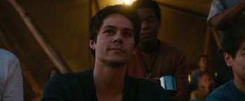 Movie still from “Maze Runner: The Death Cure” (2018), directed by Wes Ball – A man sitting next to another man in front of a tent; Close Up shot, Over the shoulder angle