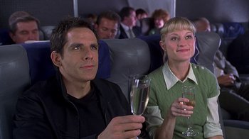 Movie still from “Meet the Fockers” (2004), directed by Jay Roach – A man and a woman sitting next to each other holding champagne flutes; Medium shot, High angle
