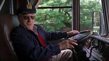 Movie still from “Meet the Fockers” (2004), directed by Jay Roach – An older man driving a bus with trees in the background; Medium shot, Low angle