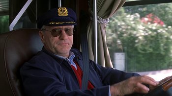 Movie still from “Meet the Fockers” (2004), directed by Jay Roach – A man wearing a hat and glasses driving a bus; Close Up shot, Low angle