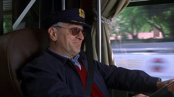 Movie still from “Meet the Fockers” (2004), directed by Jay Roach – An older man sitting on a bus wearing a hat and glasses; Close Up shot, Low angle