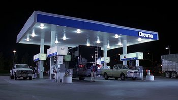 Movie still from “Meet the Fockers” (2004), directed by Jay Roach – A gas station that has a bus parked in front of it; Extreme Wide shot, Low angle