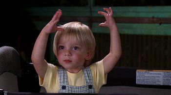 Movie still from “Meet the Fockers” (2004), directed by Jay Roach – A little boy that is holding his hands up in the air; Medium shot, Low angle