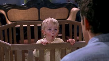 Movie still from “Meet the Fockers” (2004), directed by Jay Roach – A little boy sitting on top of a wooden bench; Close Up shot, Over the shoulder angle