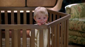 Movie still from “Meet the Fockers” (2004), directed by Jay Roach – A little boy standing in a wooden crib looking at the camera; Close Up shot, Low angle