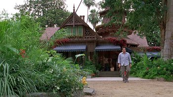 Movie still from “Meet the Fockers” (2004), directed by Jay Roach – A man standing in front of a house with a skateboard; Extreme Wide shot, Low angle
