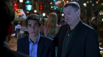 Movie still from “Meet the Fockers” (2004), directed by Jay Roach – A man standing next to another man in a suit; Medium shot, Over the shoulder angle