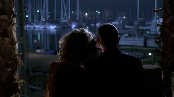 Movie still from “Meet the Fockers” (2004), directed by Jay Roach – A man and a woman sitting next to each other in front of a body of water at night; Medium shot, Over the shoulder angle