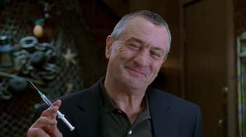 Movie still from “Meet the Fockers” (2004), directed by Jay Roach – A man in a black jacket holding a cigarette holder; Close Up shot, Low angle