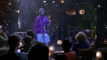 Movie still from “Meet the Fockers” (2004), directed by Jay Roach – A man standing in front of a microphone on a stage; Wide shot, Over the shoulder angle