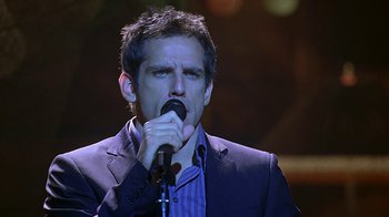 Movie still from “Meet the Fockers” (2004), directed by Jay Roach – A man in a blue jacket is singing into a microphone; Medium shot, Low angle
