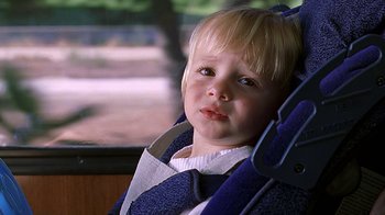 Movie still from “Meet the Fockers” (2004), directed by Jay Roach – A little boy sitting in a car seat looking sad; Close Up shot, High angle