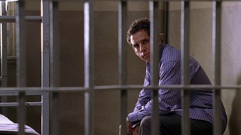 Movie still from “Meet the Fockers” (2004), directed by Jay Roach – A man sitting in front of a jail cell; Medium shot, High angle