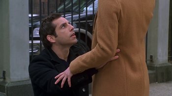Movie still from “Meet the Parents” (2000), directed by Jay Roach – A man is holding another man's hand while standing on a sidewalk; Medium shot, Over the shoulder angle