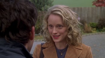 Movie still from “Meet the Parents” (2000), directed by Jay Roach – A woman with blonde curly hair wearing a brown jacket; Close Up shot, Over the shoulder angle